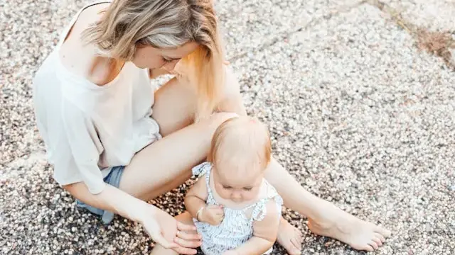Mutter mit Kleinkind auf dem Boden spielend